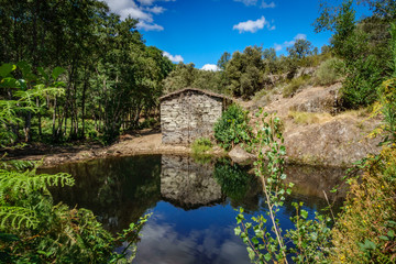 Fototapeta na wymiar Old abandoned watermill and pond