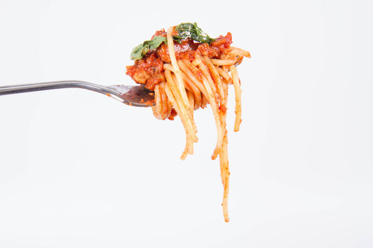 Spaghetti bolognese on a fork on a white background