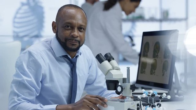  Portrait smiling medical researcher working in high tech lab