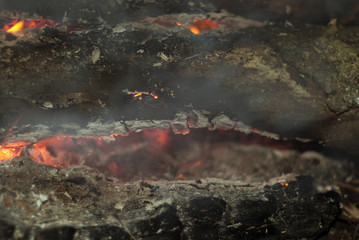 Smoldering firewood in a fire close up