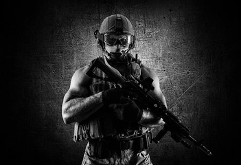 The soldier of the special unit stands with an automatic weapon at the advantage.