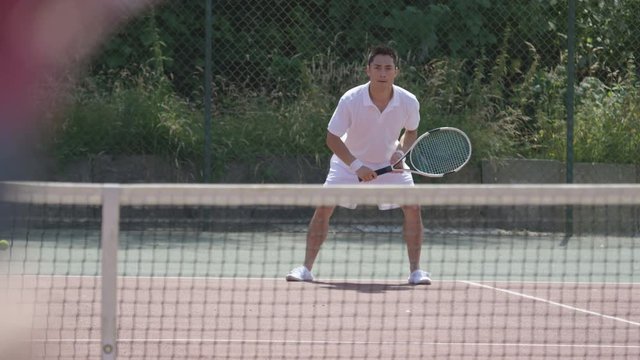  Male tennis players enjoying a game on outdoor court in the summer
