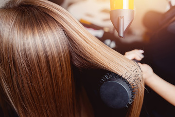 Close-up of hair dryer for hair drying, concept hair salon, female stylist. - obrazy, fototapety, plakaty