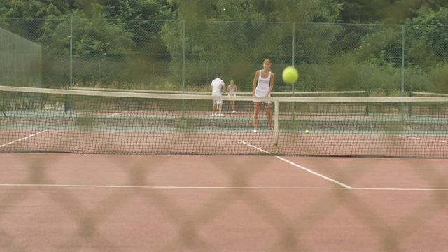  Female tennis player practicing her serve on outdoor court in the summer.