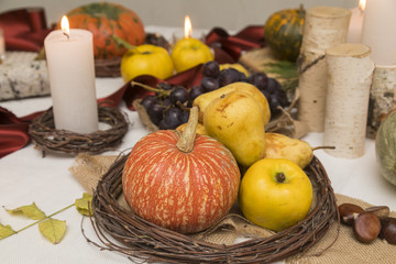 Autumn arrangement with tasty pears,quince, pumpkins and candles.