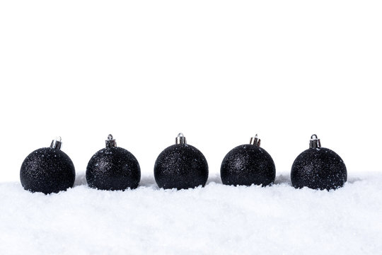 Five Black christmas balls with snow isolated on white background