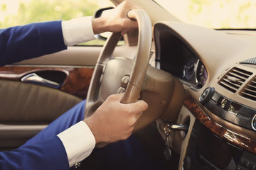 Young businessman driving a car, closeup