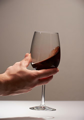 Elegant hand with red wine glass