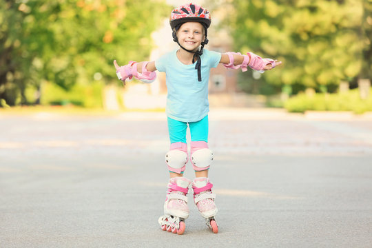 Little girl on roller skates in summer park