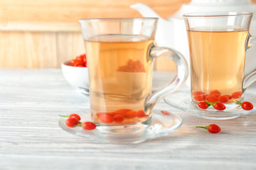 Glasses with goji tea on wooden table