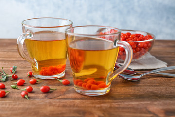 Cups with goji tea on wooden table
