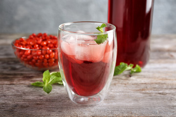 Glass with goji juice on wooden table