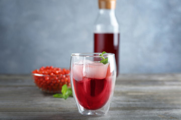 Glass with goji juice on wooden table