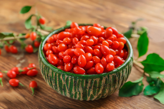 Bowl with goji berries on wooden table