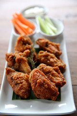Buffalo wings barbecue chicken with carrots  and cucumbers on wood background