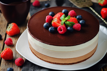 Triple chocolate mousse cake decorated with fresh berries