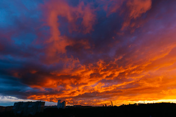 Panoramic view of apocalypse sky over city. Unbelievable nature landscape. Fantastic and outlandish stormy clouds. Warm and cold. Heaven battle. Hell and heaven fight. Colorful impressive paysage.