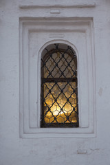 Fototapeta premium Light in a window of strary Christian church. Architecture