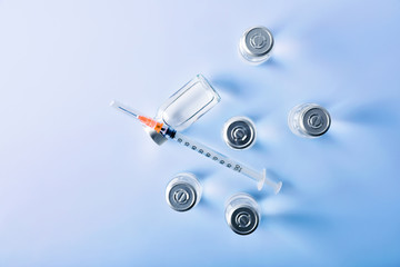 Group of vials and syringe on blue table top view
