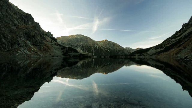 Time lapse reflection of clouds and shadow monsters in lake Morskie Oko, Tatras mountains, Poland landscape background