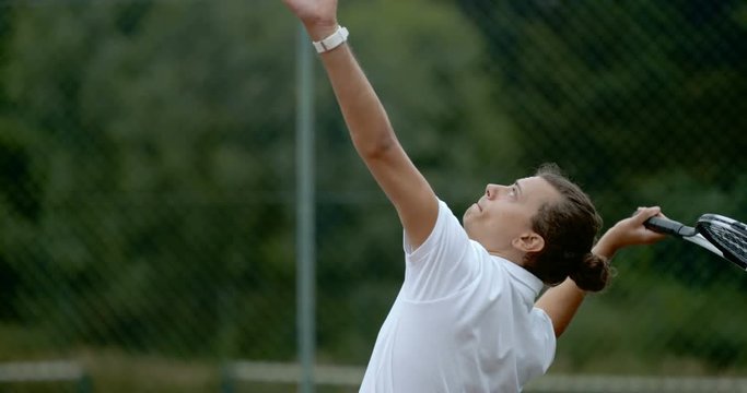  Male tennis player throws ball into the air to serve in super slow motion