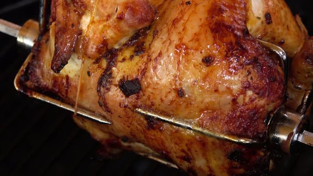 Fragrant chicken is roasted on skewers on the grill rotating