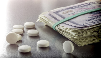 Some white capsules along with tickets of dollar, conceptual image