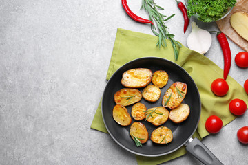 Composition with delicious rosemary potatoes in pan on table