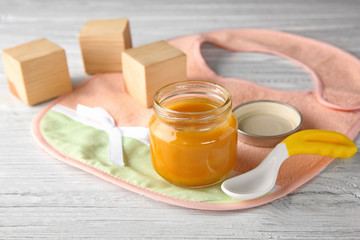 Jar with baby food on wooden table