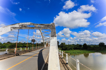 Old white bridge, bright sky and river in Thailand, beautiful background 