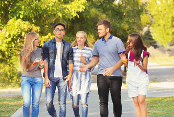 Happy teenagers walking on city street