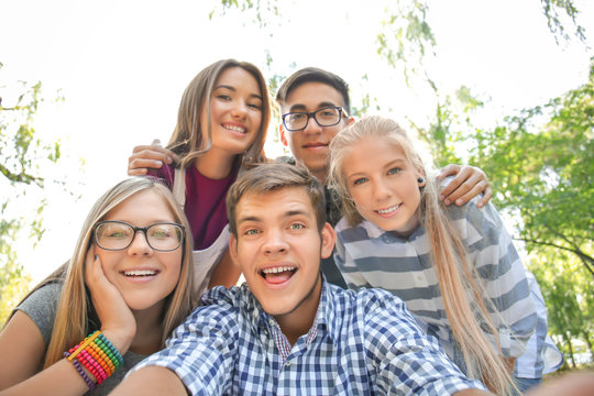 Happy teenagers taking selfie outdoors