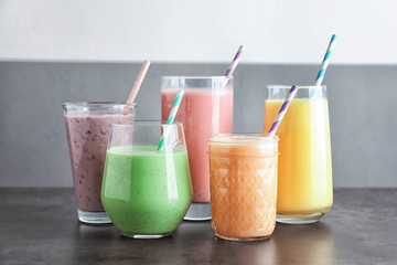 Different fruit milkshakes in glassware on table