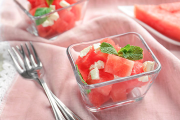 Bowl of fresh salad with watermelon on table
