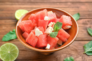 Bowl of fresh salad with watermelon on table