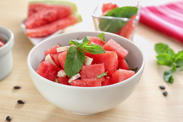 Bowl of fresh salad with watermelon on table