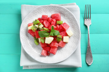 Plate of fresh salad with watermelon on table