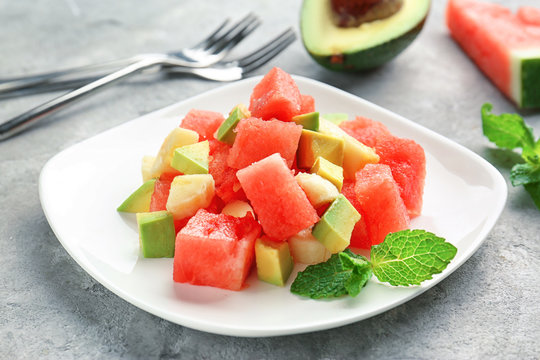 Plate of fresh salad with watermelon on table
