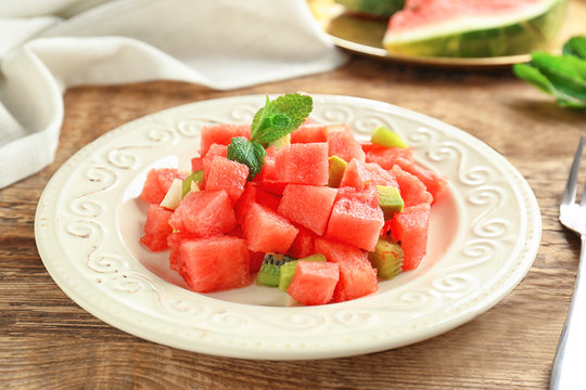 Plate of fresh salad with watermelon on table