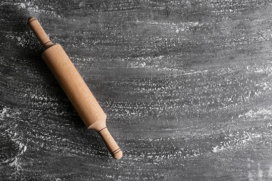Scattered flour and rolling pin on gray background