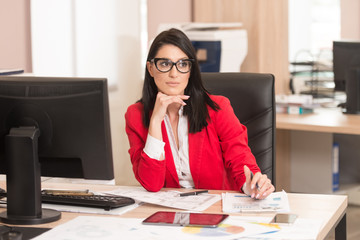 Businesswoman Sitting At Office Desk Signing A Contract