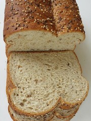 Whole grain sliced loaf bread on white background, closeup