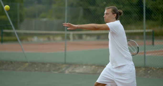  Super slow motion male tennis player hitting the ball during a game