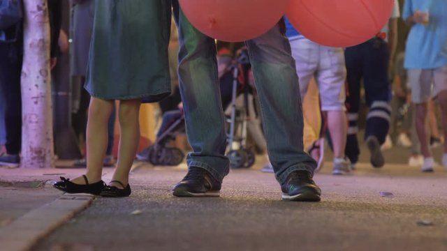 Cropped image of young father and his cute little daughter in the middle of crowd