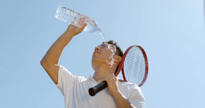  Super slow motion, male tennis player pouring water on his head to cool down.