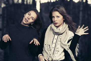 Two young fashion teen girls walking in autumn park