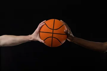 Gordijnen Competitors holding basketball against black background © wavebreak3