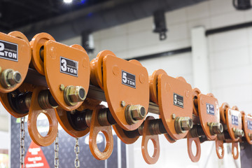 Industrial Steel Chains in orange hoists ; Selective focus