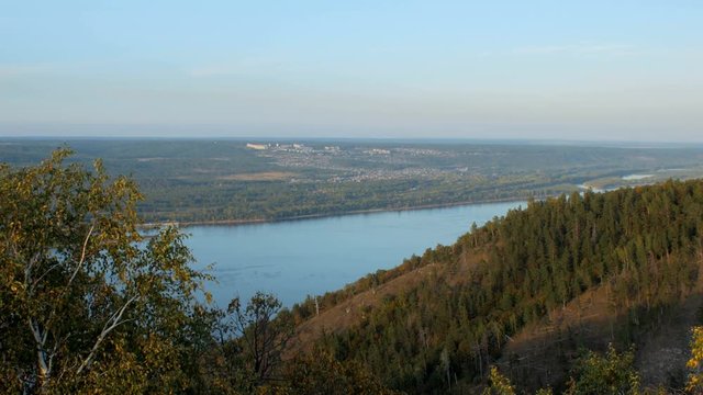 top view of wide river and small city near in sunny summer day, slopes of hills