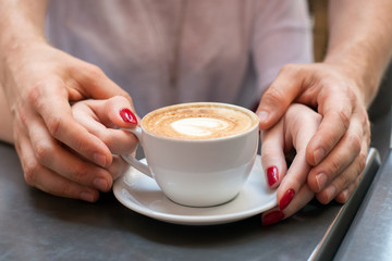 Hands of a man and a woman and coffee cup